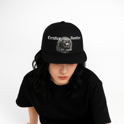 Person wearing a black cap and black t-shirt with text, sitting on a white background